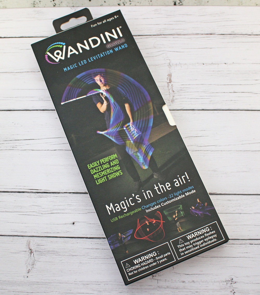 A box for a Wandini Magic LED Levitation Wand displays a person using the glowing wand, creating colourful light trails. The packaging highlights features like mesmerising light shows and USB rechargeability.