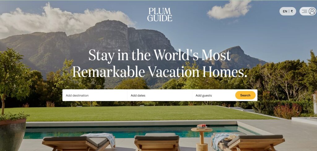 A luxurious outdoor swimming pool area with sun loungers overlooks lush greenery and mountains, with PLUM GUIDE and a search bar inviting users to find remarkable holiday homes.
