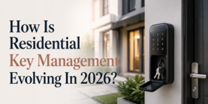 A smart key lockbox with keys inside is mounted on a wall near a modern home's front door. Text reads, “How Is Residential Key Management Evolving In 2026?”.