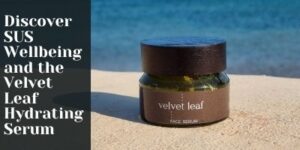 A jar of Velvet Leaf Face Serum sits on a sandy surface by the sea. Text on the left reads: Discover SUS Wellbeing and the Velvet Leaf Hydrating Serum.