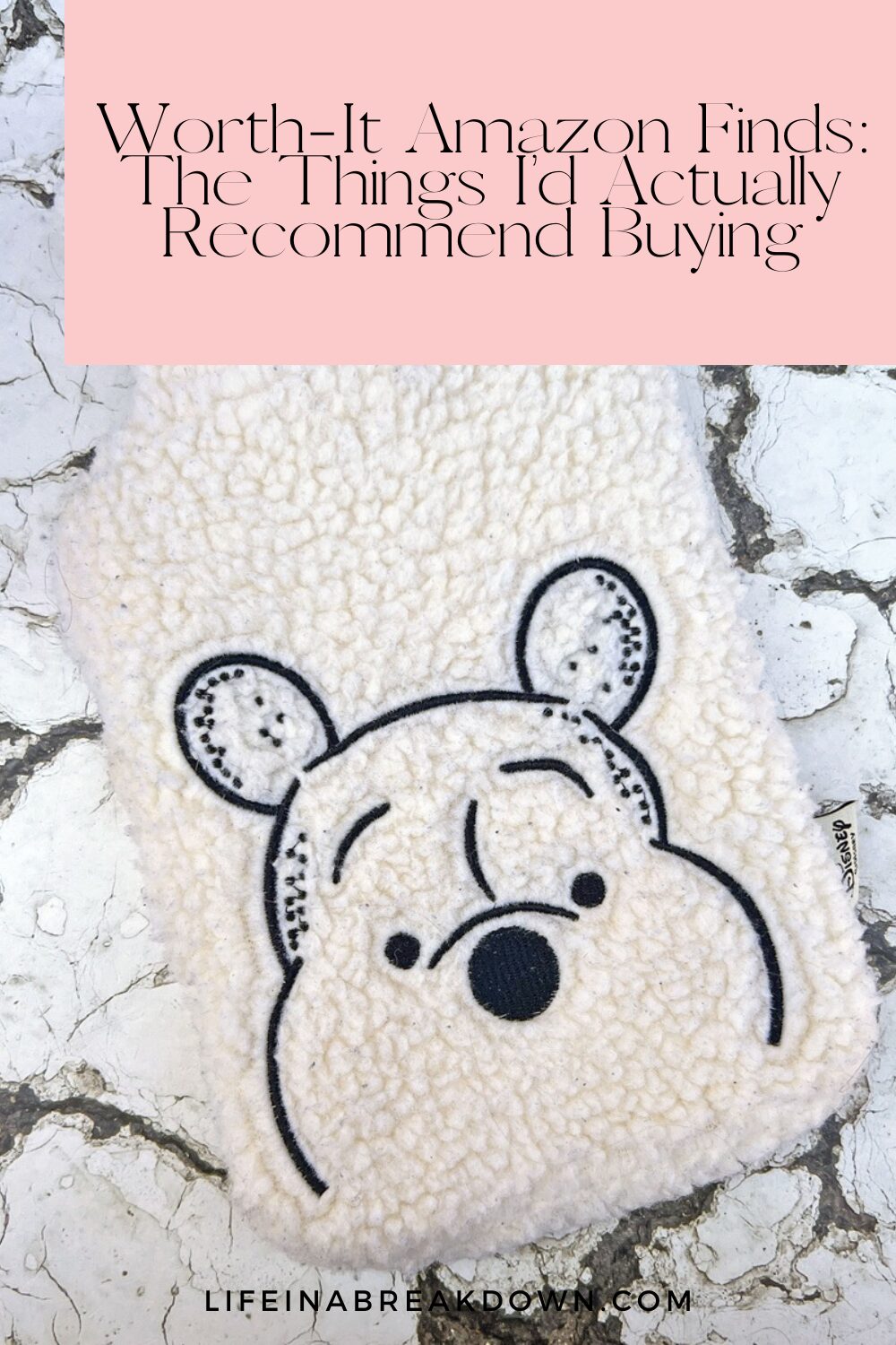 A fluffy white pouch with a bear face design lies on a cracked white surface. Text above reads, Worth-It Amazon Finds: The Things I’d Actually Recommend Buying.