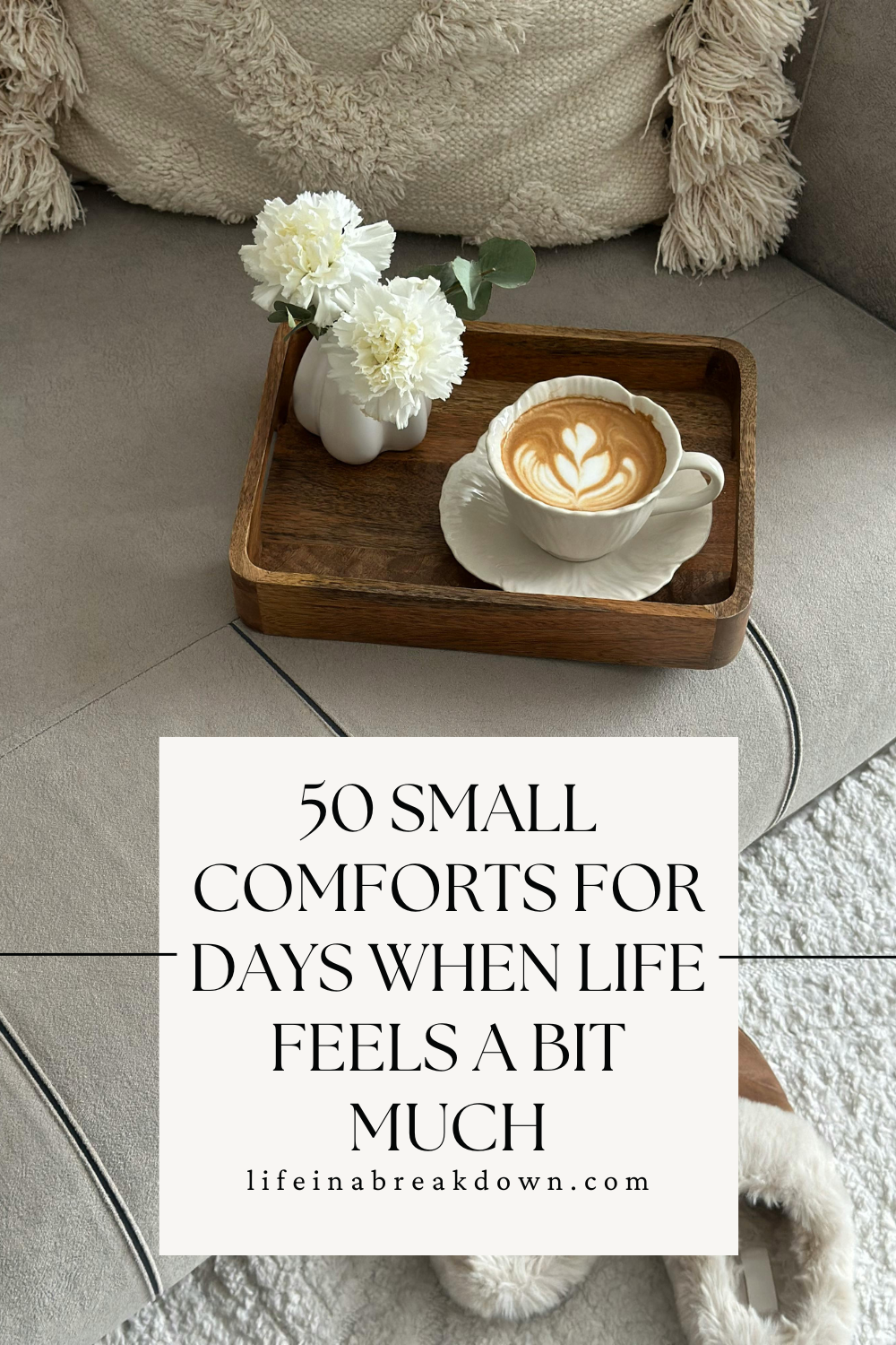 A wooden tray with a cappuccino and flowers on a cosy sofa. Text reads: 50 small comforts for days when life feels a bit much. lifeinabreakdown.com..
