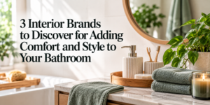 A bathroom worktop with green towels, a candle, soap dispensers, and a potted plant. Text reads: 3 Interior Brands to Discover for Adding Comfort and Style to Your Bathroom.