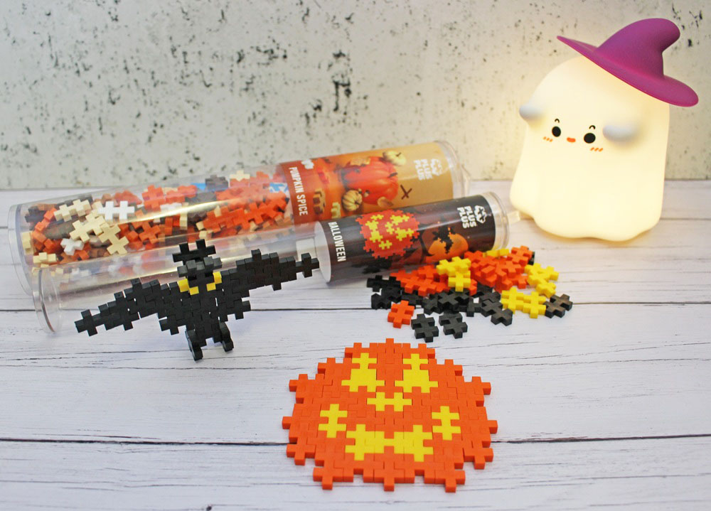 Plus-Plus building block sets for Hallowe’en, including a bat and a jack-o’-lantern made of blocks, with two storage tubes and a glowing ghost lamp.